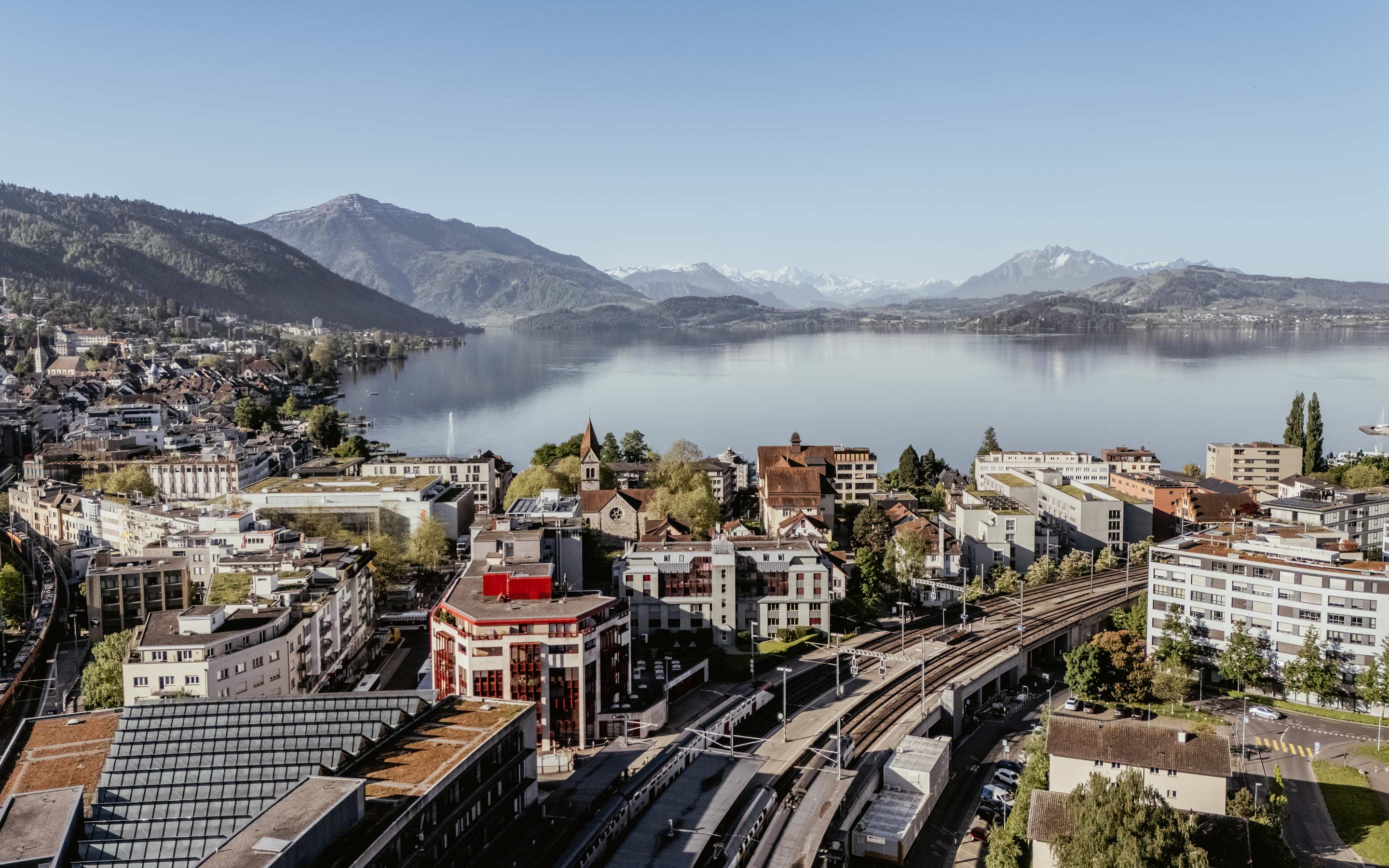 Drohnenaufnahme-Stadt-Zug-mit-Bahnhof-und-Zugersee_Zug_Fruhling_Bissig